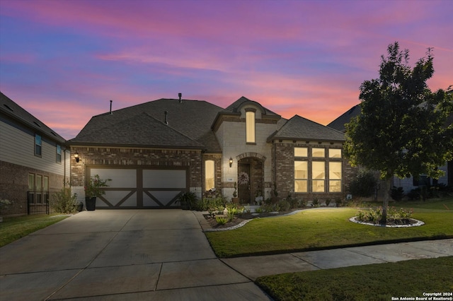 view of front of home featuring a garage and a lawn