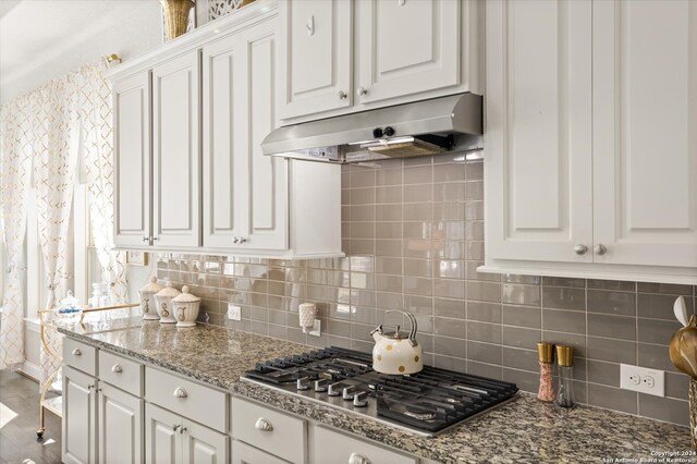 kitchen with white cabinetry, gas cooktop, light stone counters, and tasteful backsplash