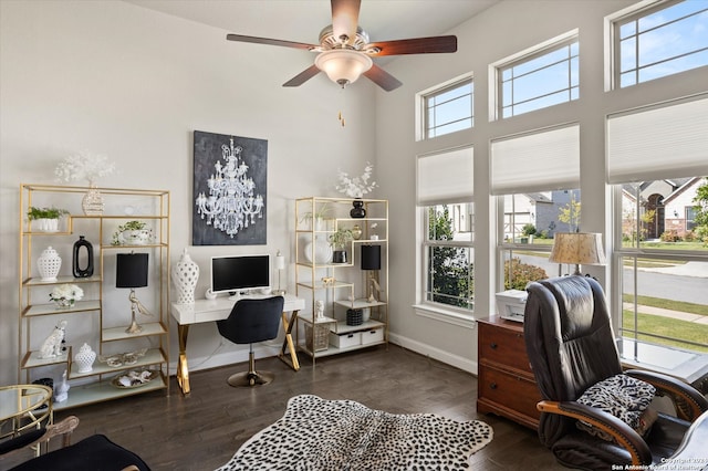 office space with ceiling fan, a towering ceiling, a healthy amount of sunlight, and dark hardwood / wood-style floors