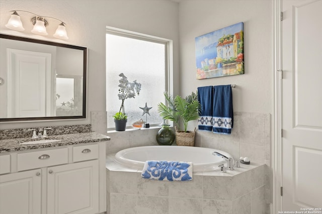 bathroom with vanity and tiled tub