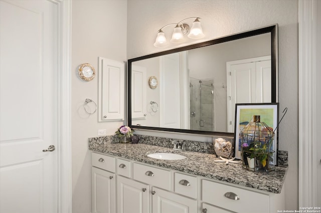 bathroom featuring walk in shower and vanity