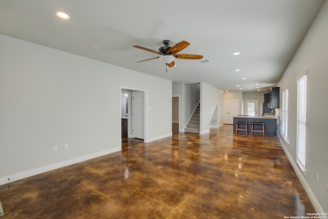 unfurnished living room featuring ceiling fan