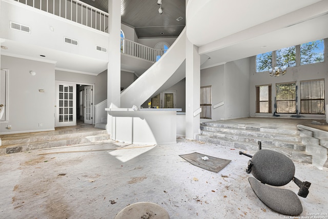 living room with crown molding and high vaulted ceiling