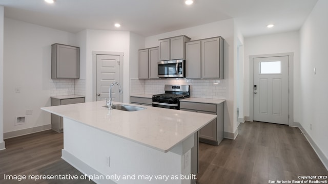 kitchen with gray cabinetry, a kitchen island with sink, sink, and stainless steel appliances