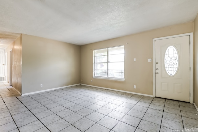 entrance foyer with a textured ceiling and light tile patterned floors