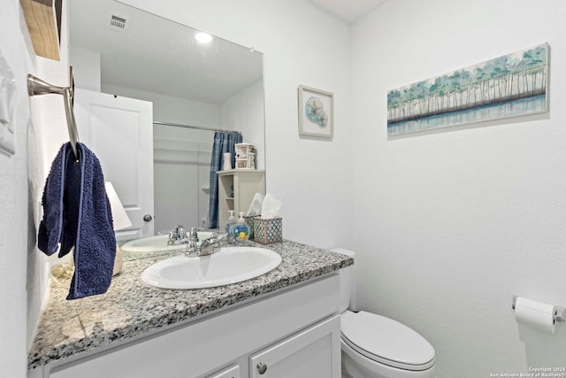 bathroom featuring vanity, toilet, and a shower with shower curtain