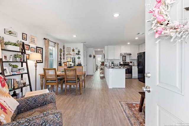 living room with light hardwood / wood-style floors and sink