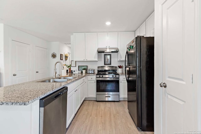 kitchen featuring light hardwood / wood-style flooring, sink, kitchen peninsula, white cabinets, and appliances with stainless steel finishes