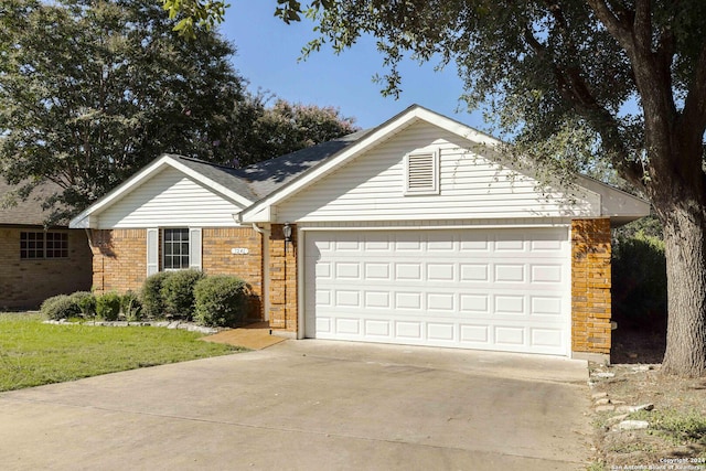 ranch-style house featuring brick siding, an attached garage, driveway, and a front yard