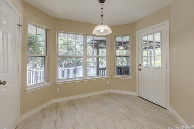 unfurnished dining area with marble finish floor and baseboards
