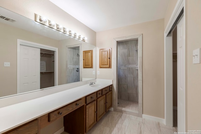 bathroom featuring a tile shower and vanity