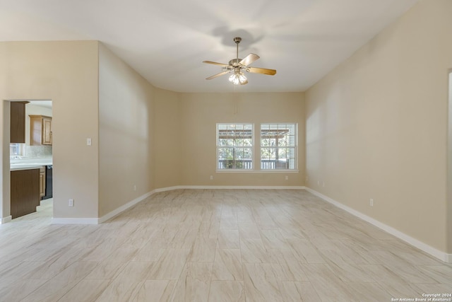 empty room with baseboards and a ceiling fan