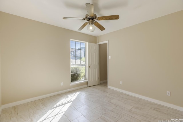 spare room featuring baseboards and ceiling fan
