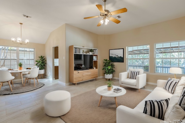 living room with ceiling fan with notable chandelier, plenty of natural light, light hardwood / wood-style floors, and lofted ceiling