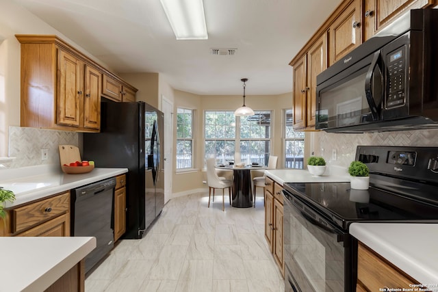 kitchen with pendant lighting, black appliances, and tasteful backsplash