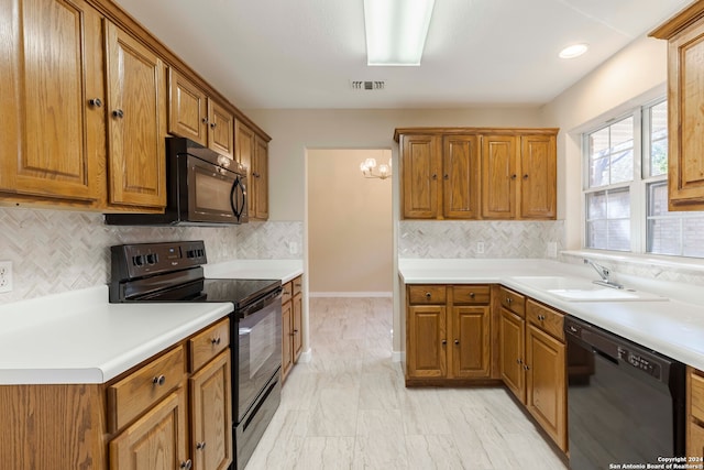 kitchen with decorative backsplash, black appliances, and sink