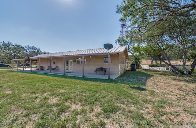 back of house with a lawn and a patio