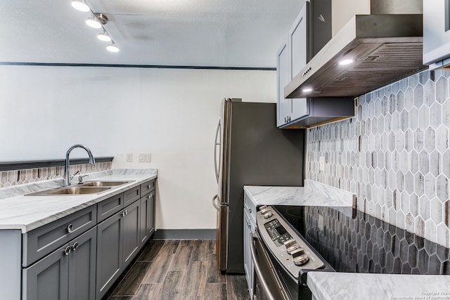 kitchen with sink, dark wood-type flooring, wall chimney range hood, gray cabinets, and stainless steel range