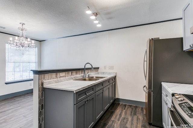 kitchen featuring dark hardwood / wood-style floors, gray cabinetry, sink, pendant lighting, and appliances with stainless steel finishes