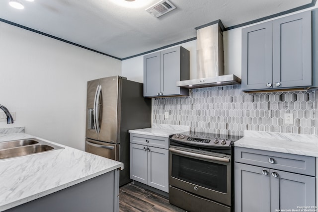 kitchen with gray cabinetry, wall chimney exhaust hood, stainless steel appliances, and dark hardwood / wood-style flooring