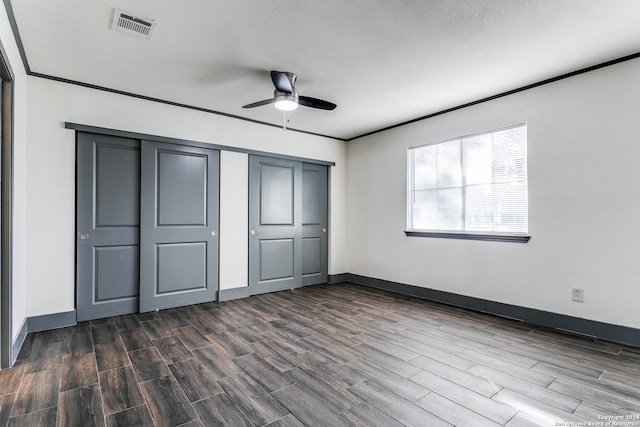 unfurnished bedroom with ceiling fan, dark wood-type flooring, and a textured ceiling