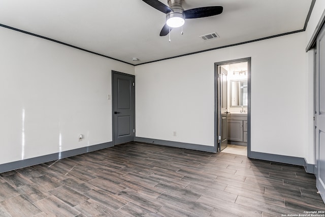 unfurnished bedroom with dark wood-type flooring, ceiling fan, crown molding, and ensuite bath