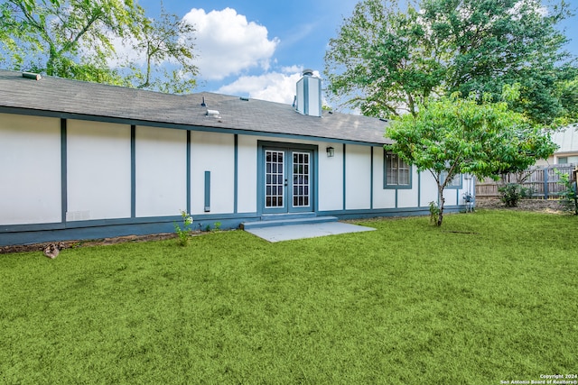 back of property with a yard and a patio area