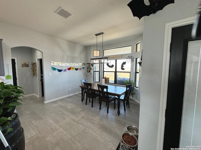 dining room featuring a textured ceiling and a notable chandelier