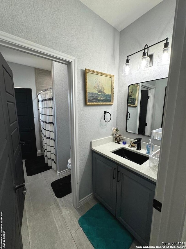 bathroom featuring vanity, walk in shower, and toilet