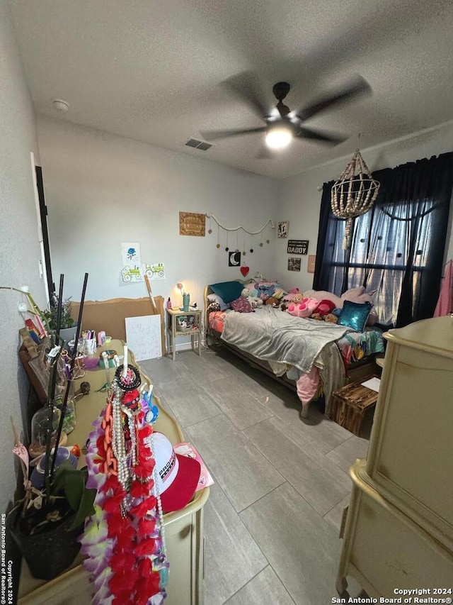 bedroom with ceiling fan and a textured ceiling