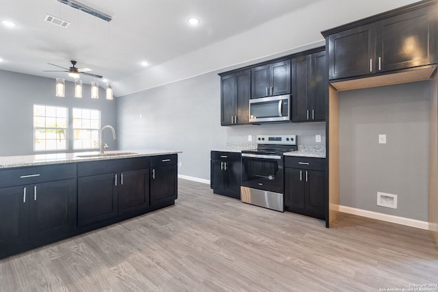 kitchen featuring light stone counters, ceiling fan, stainless steel appliances, sink, and light hardwood / wood-style floors