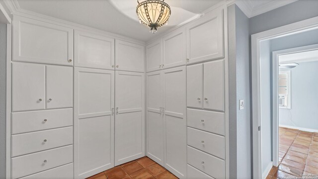 walk in closet with light tile patterned floors and a chandelier