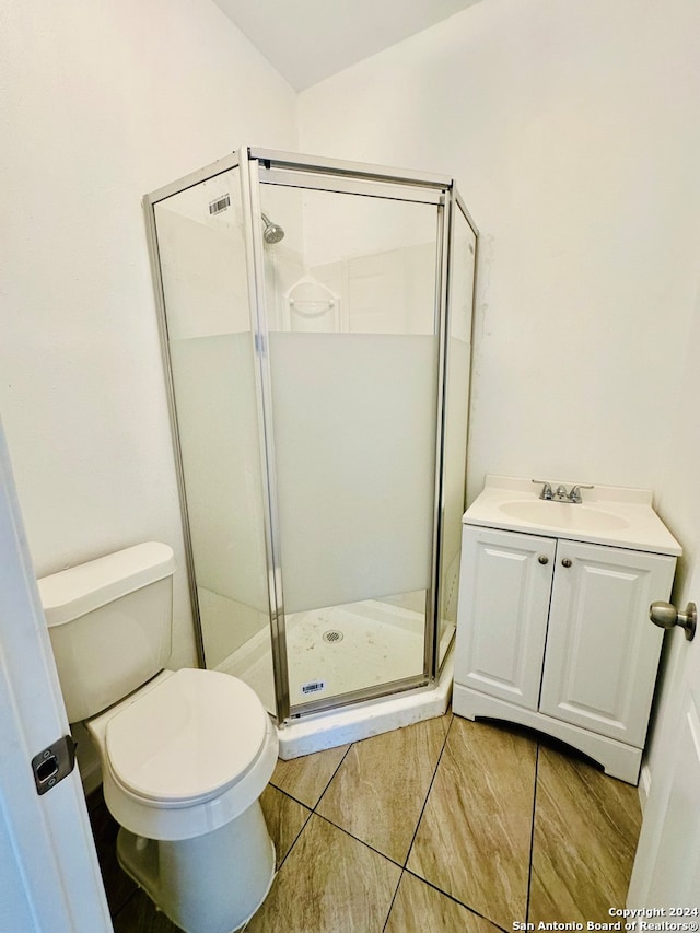 bathroom with vanity, a shower with shower door, and toilet