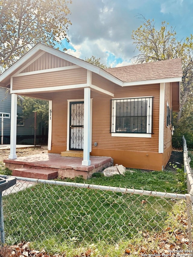 view of front of home with a front yard and covered porch