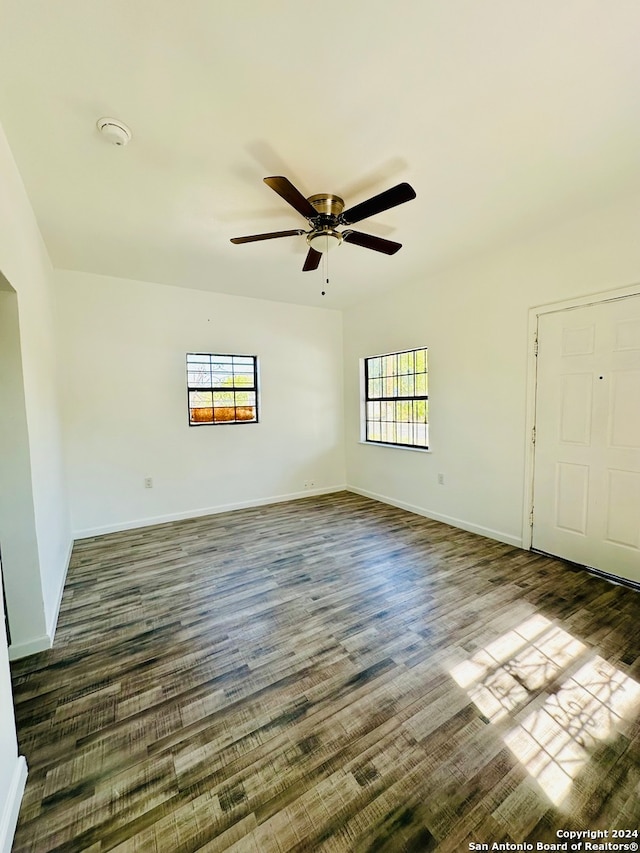 unfurnished room featuring ceiling fan and dark wood-type flooring