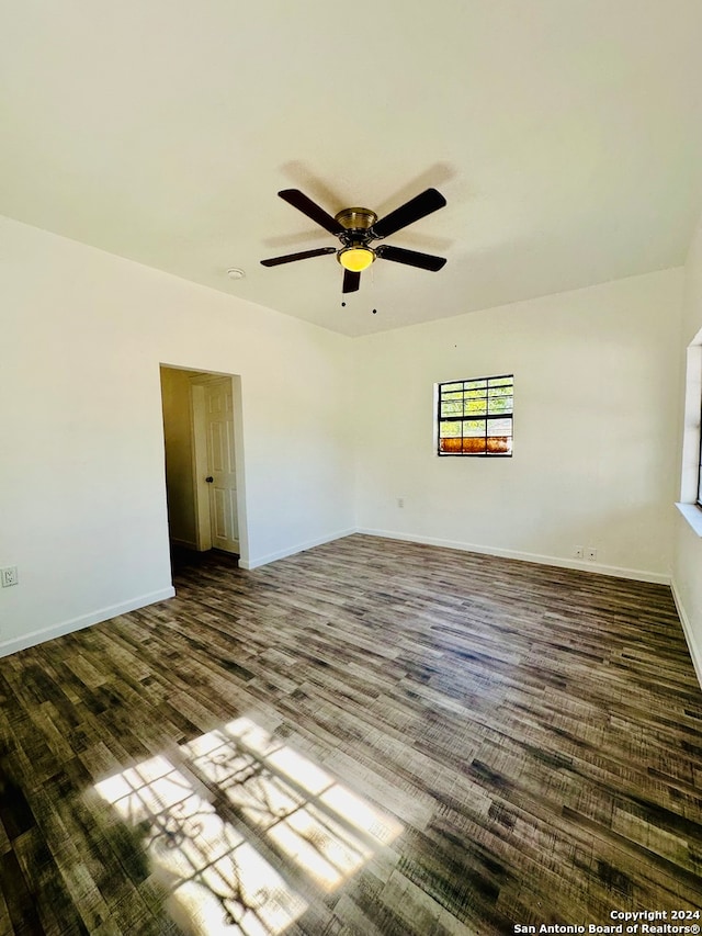 spare room with dark hardwood / wood-style floors and ceiling fan