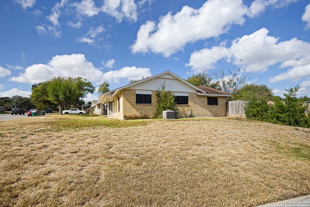 view of side of property with central air condition unit and a lawn