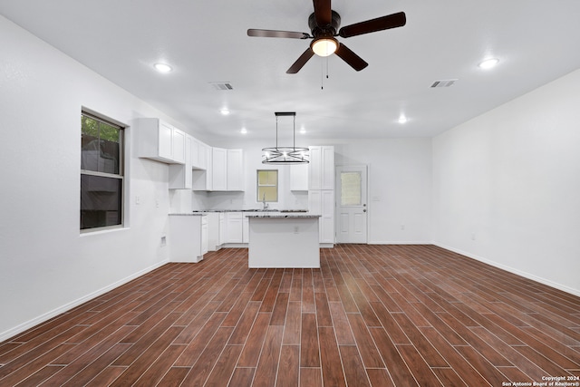 kitchen with a center island, dark hardwood / wood-style floors, ceiling fan with notable chandelier, white cabinetry, and decorative light fixtures