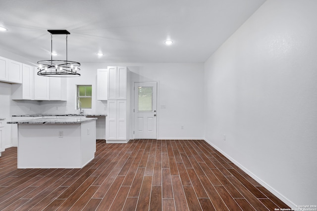 kitchen featuring white cabinets, decorative light fixtures, dark hardwood / wood-style floors, and a center island