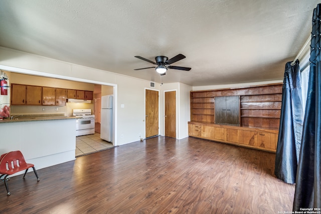 unfurnished living room featuring ceiling fan, light hardwood / wood-style floors, and a textured ceiling