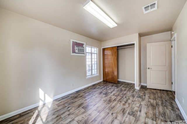 unfurnished bedroom featuring hardwood / wood-style flooring and a closet