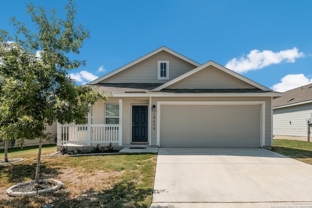 view of front of home with a garage, a front lawn, and covered porch