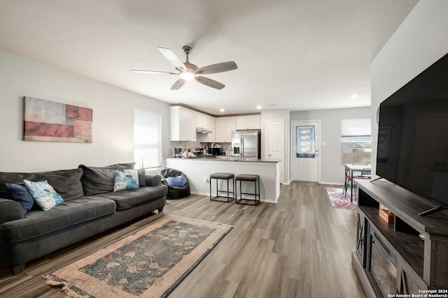 living room with light wood-type flooring and ceiling fan