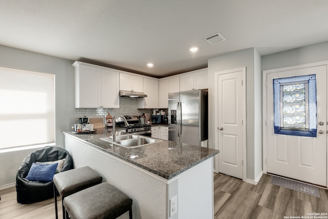 kitchen with white cabinets, stainless steel appliances, sink, and kitchen peninsula