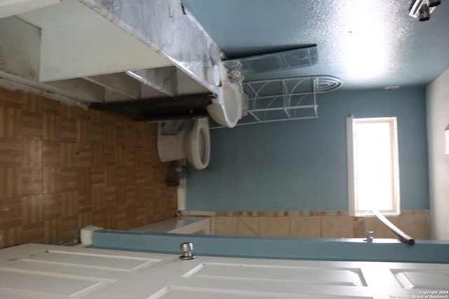 bathroom featuring wooden walls