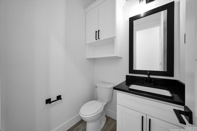 bathroom with vanity, hardwood / wood-style flooring, and toilet