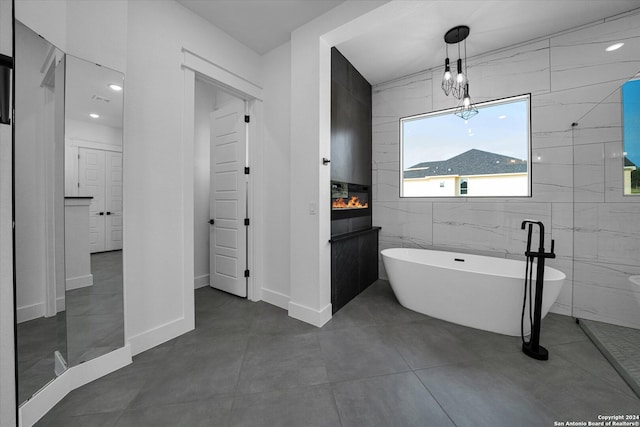 bathroom featuring tile walls, vanity, a tub to relax in, and tile patterned floors