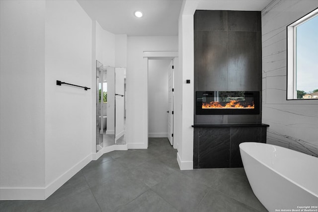 bathroom with a tub to relax in, tile walls, and a wealth of natural light