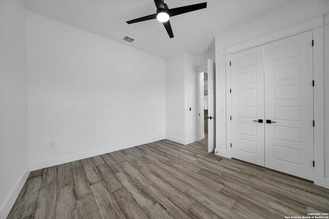 unfurnished bedroom with light hardwood / wood-style flooring, a closet, and ceiling fan