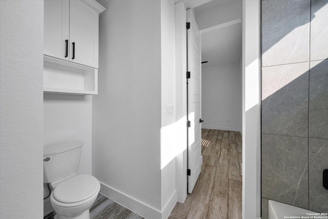 bathroom featuring toilet, hardwood / wood-style flooring, and a shower